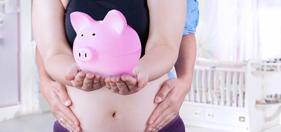 pregnant woman holding piggy bank