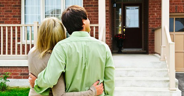 young couple in front of first house