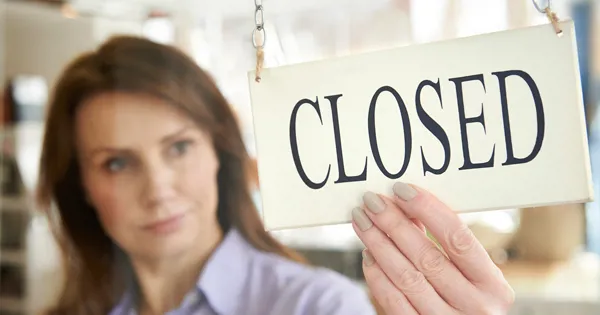 woman holding sign that says closed