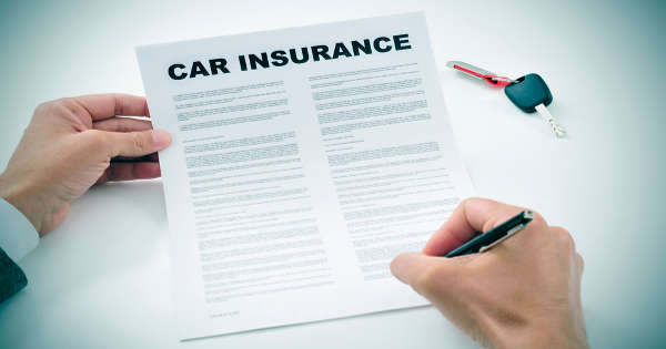 Man signing car insurance policy