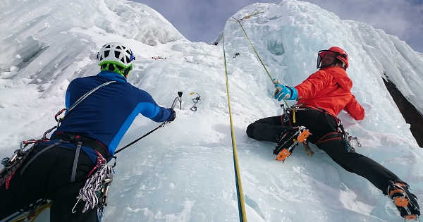 men climbing ice covered mountain