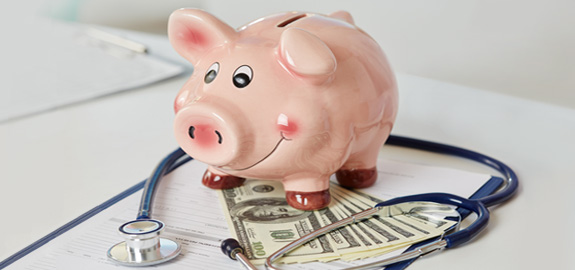 piggy bank on money and stethoscope