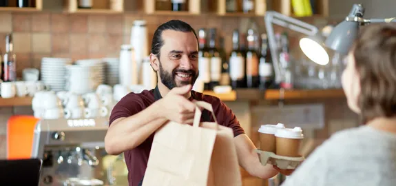 small business owner handing customer bag