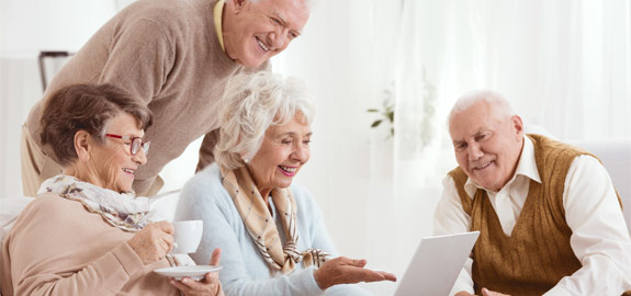 four seniors looking at computer screen