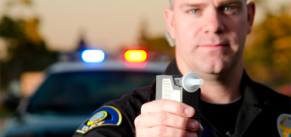 police officer holding breathalyzer