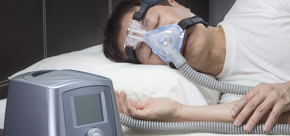 sleeping man wearing cpap machine mask