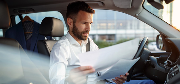 Man looks at papers in car