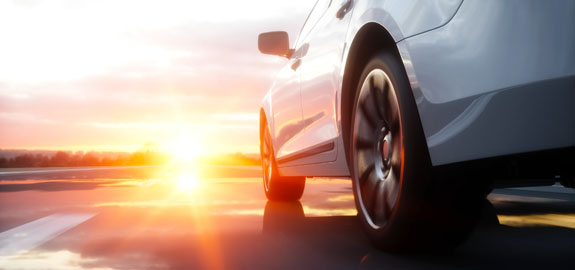 Luxury car cruising at sunset